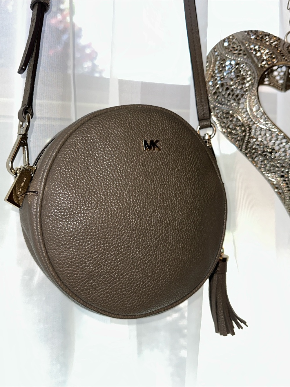 Michael Kors Round Pebbled Leather Crossbody in brown with Tassel